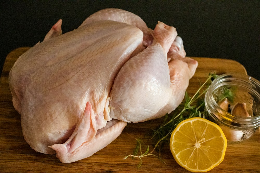 Whole raw chicken with lemon and rosemary
